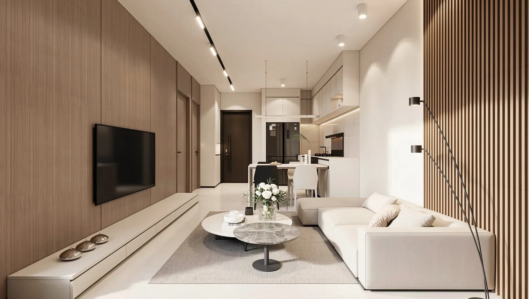 A living room with a cream sofa, a television on a timber wall and a kitchen behind